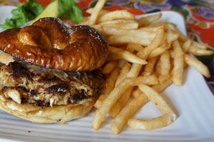 Crab cake sandwich on pretzel bun with golden fries