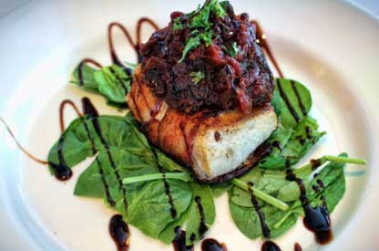 Seared fish fillet on fresh spinach with balsamic reduction