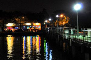 O'Maddy's at night with colorful lights reflecting on Boca Ciega Bay