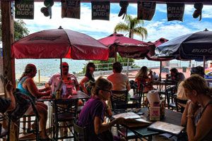 Outdoor patio seating under umbrellas with bay water visible in the background