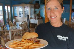 Server proudly presenting a burger plate with fries